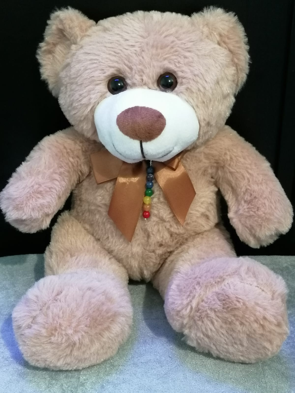 My reiki bear, River. A light brown teddy bear with a brown satin bow around its neck. It has a chakra crystal charm around it's neck